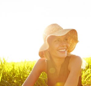 A beautiful young blonde woman sitting in a field