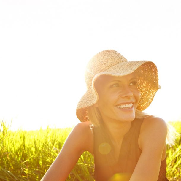 A beautiful young blonde woman sitting in a field