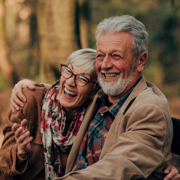 Couple loving each other on a bench in the woods.