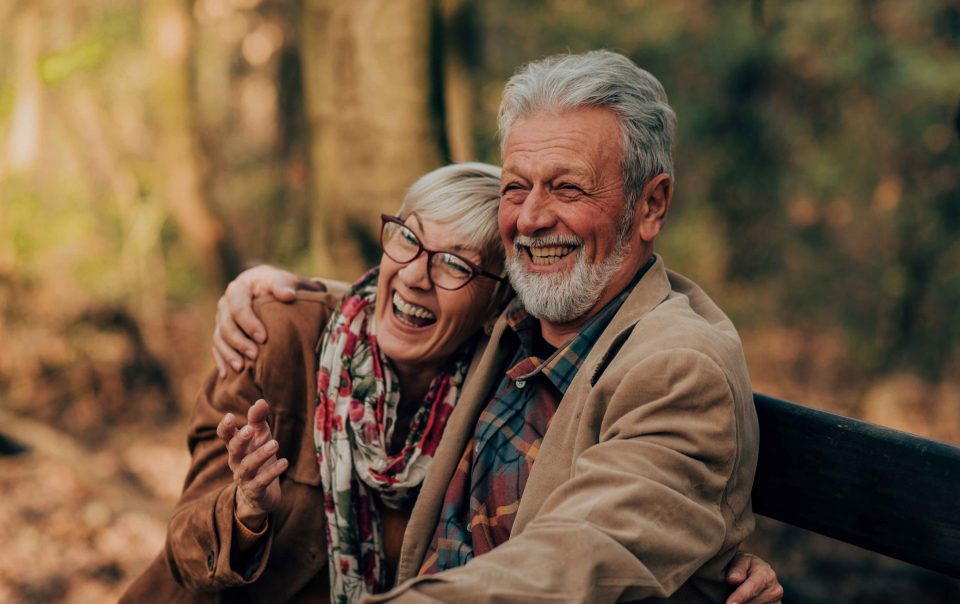 Couple loving each other on a bench in the woods.