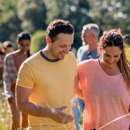 Couples walking through Terbury countryside in the summer after staying at the Snooty Fox
